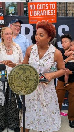 Council Member Mercedes Narcisse at the podium. Left to right behind: CMs Gale Brewer, Justin Brannan, Crystal Hudson and baby.