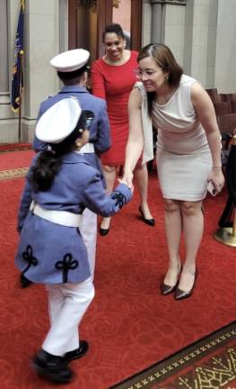 Miguelina Camilo, counsel to the speaker for the New York State Assembly, shakes hands with Leah, a six-year-old young cadet in the Knickerbocker Greys.