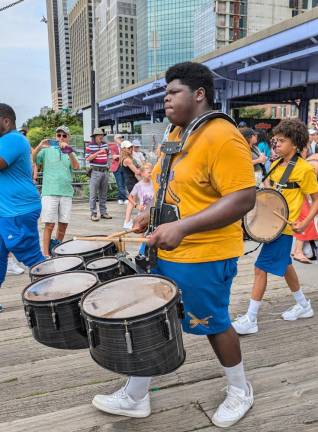 And the Big Man joined the band! Sweat soaked drummer from the Factor Marching Band of Vernon, NJ keeps the rhythms going at the 4th of July parade’s end at South Street Seaport.