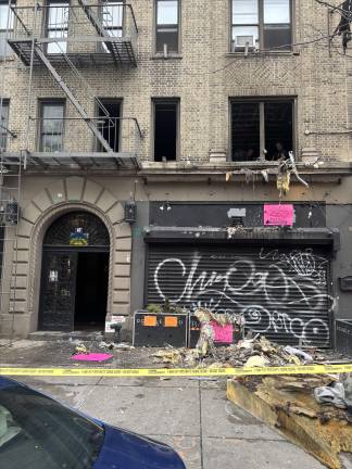 Debris that firefighters tossed from the second-floor apartment where the fire erupted lies on the sidewalk outside the six-story building on Second Avenue near East 4th Street. One person died in the Feb. 2 fire.