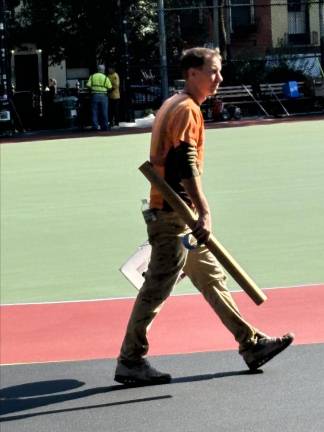 A Parks Department worker inside the shut-down playground in the E. 10th St. end of Tompkins Square Park as it underwent final touching up before the playground that was once a haven for skateboarders reopens as a multi-purpose, newly painted asphalt play area with a new running track.