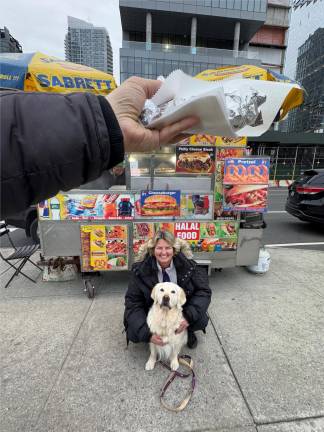 Maui, a nine-year-old Golden Retriever with owner Sabrina Lanz, is about to devour a free hotdog from a street vendor captured by our photographer.