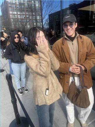 Camera shy fan Ma Yeonju and her boyfriend Maceo Hembert on line to get into the Gensis pop up store to get flowers and immersive photo ops celebrating release of the <i>Sweet Dreams </i>single by j-hope of the popular K-pop band BTS.