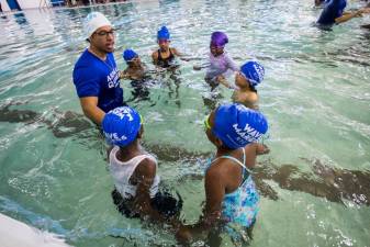 An instructor gives lessons to young swimmers following the ribbon cutting ceremony for the pool reopening at River East Elementary (2351 1st Avenue in Manhattan) on Friday, October 25, 2024. Up to 600 second graders will be eligible for free swimming lessons.