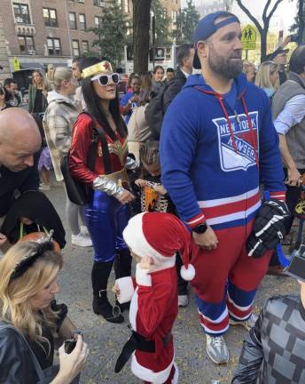 Parents get into the festive spirit along with the kids from the Epiphany School at the annual Halloween parade.