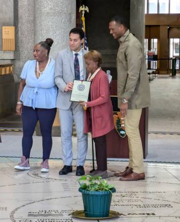 Lorraine Dimson, director of the Southbridge Towers Senior Center, receives her award; District Leader Mariama James at left.