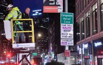 MTA chairman Janno Leiber unveils a congestion pricing sign at midnight on Sunday, Jan. 5 on the first day of the toll.