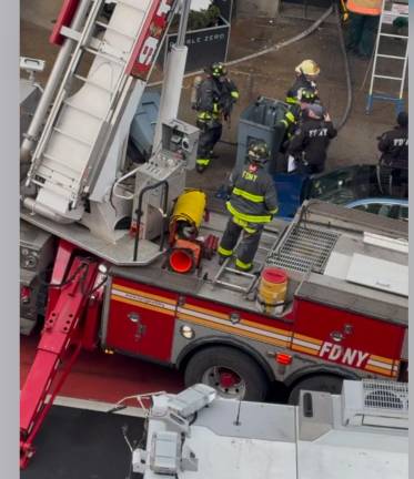 The firefighter in the rear is holding Bella, the Miniature Pinscher that he rescued from the fire that killed her owner on Feb. 2 in an East Village apartment fire. Sadly, Bella herself died five days later.