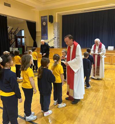 Students in blue and gold, the school colors, receive the blessing of St. Blaise.