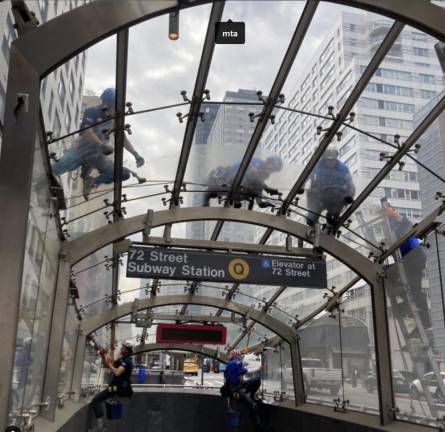 Workers clean the station roof at 72nd Street Q train entrance, June 2023.