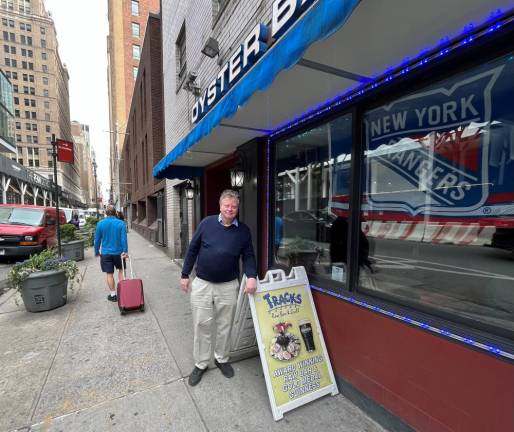 Bruce Caulfield stands near a New York Rangers banner hanging inside Tracks Bar &amp; Grill on W. 31st. St. across from Madison Square Garden. Photo: Ralph Spielman