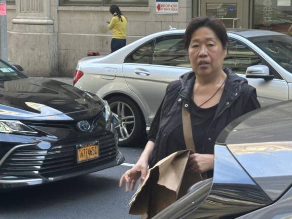 A woman crosses street between moving cars on W. 38th St. As of Feb. 1, she can’t be hit with a summons since the six decade administrtive law outlawing jaywalking has been repealed by the City Council.