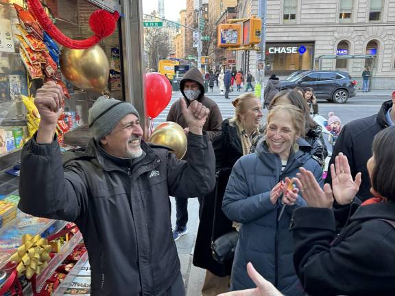 Having just cut the red ribbon and declared victory, Sadik “Sami” Topia cheers and pumps his fists as the crowd cheers for the return of the newsstand, a community fixture on the UWS for over two decades before he ran into fines and ownership issues that forced its temporary closing.