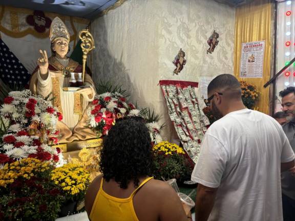 Festival goes pin money onto the San Genarro statue with the hope that the saint from Naples, Italy, will bestow good fortune on them in the year ahead.