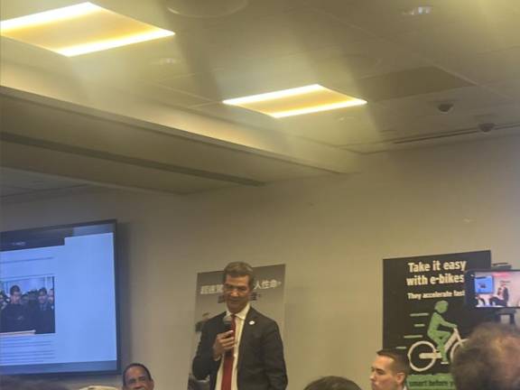 NYC DOT Commissioner Ydanis Rodriguez speaking at a Jan. 15 media roundtable, where he touted a new “Microhubs” pilot program and discussed the ongoing “Get Smart Before You Start” e-bike safety campaign (pictured on poster, back-right).