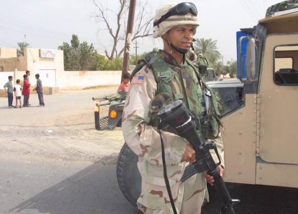 Aquilino Gonell prepares to escort a convoy while serving in Iraq with the US Army