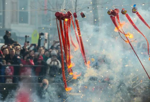 Plenty of pop and sizzle as firecrackers explode at the Lunar New Year parade in Chinatown.