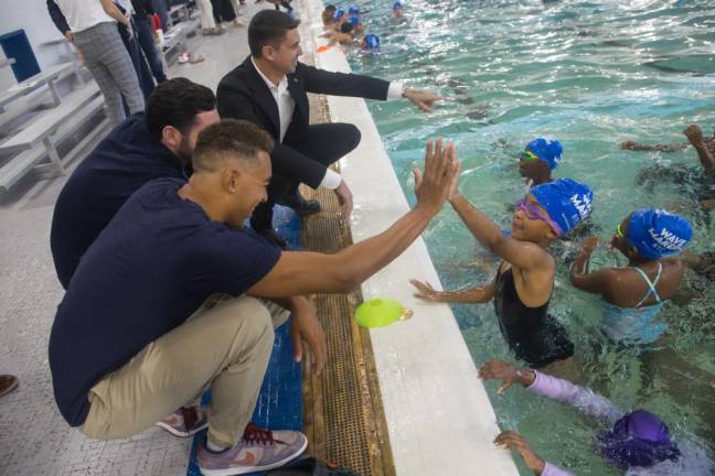 Young swimmers dive in after the ribbon cutting ceremony for the pool reopening at River East Elementary (2351 1st Avenue in Manhattan) on Friday, October 25, 2024.