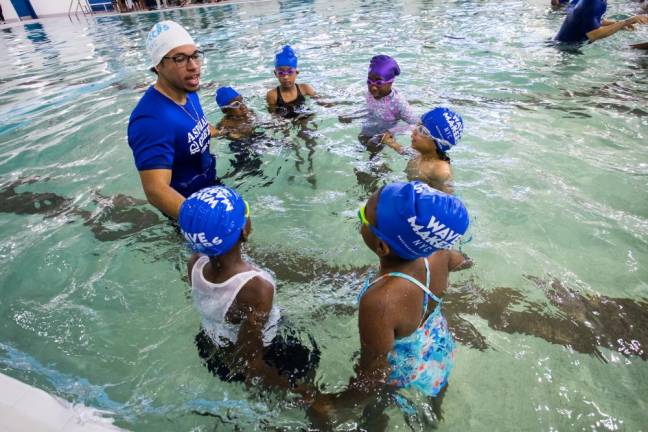 An instructor gives lessons to young swimmers following the ribbon cutting ceremony for the pool reopening at River East Elementary (2351 1st Avenue in Manhattan) on Friday, October 25, 2024. Up to 600 second graders will be eligible for free swimming lessons.