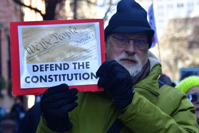 One of the hundreds of marching protestors in Union Square on Feb. 17 carrying a sign reading “DEFEND THE CONSTITUTION.”