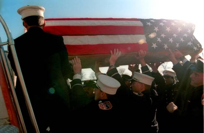 A flag draped coffin at a memorial service for Battalion Chief Ed Geraghty was largely symbolic since his remains had not been recovered from Ground Zero.