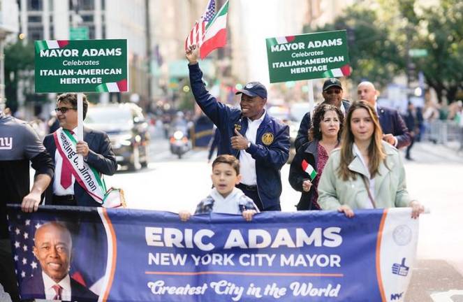 Mayor Eric Adams sidestepped controversy by having his aids carry signs that said he “celebrates Italian-American Heritage. Photo: NYC Mayor’s Office