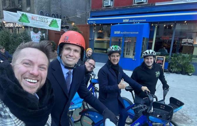 Council member, Erick Bottcher (red helmet) cycling on the redesigned bike lane on Tenth Avenue.