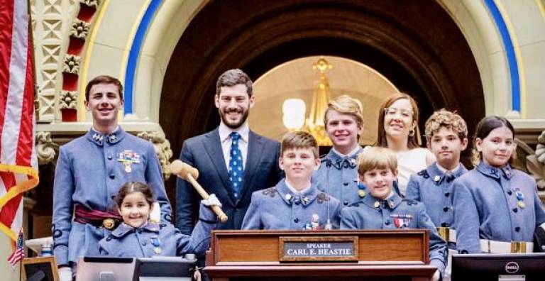 The Knickerbocker Greys smile with Alex Bores, Assembly member and sponsor of the bill, and Miguelina Camilo, counsel to the speaker for the New York State Assembly.