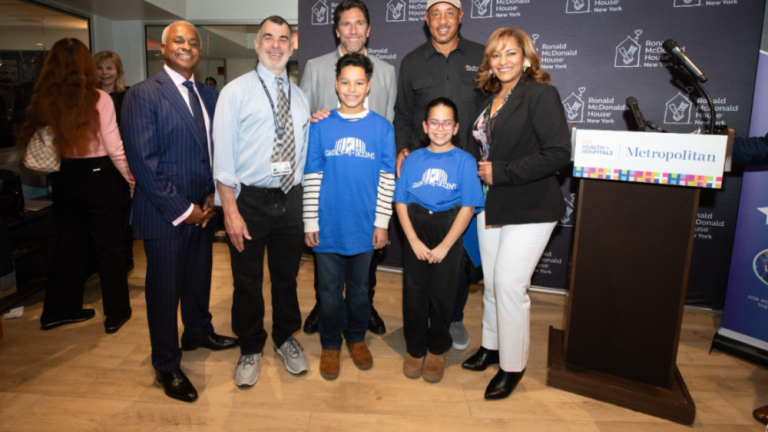 Rangers legend Henrik Lundquist (rear row left) and Knicks star John Starks (rear row right) gather with staff and patients at Metropolitan Hospital to dedicate two new rooms available to families with kids undergoing cancer treatments.