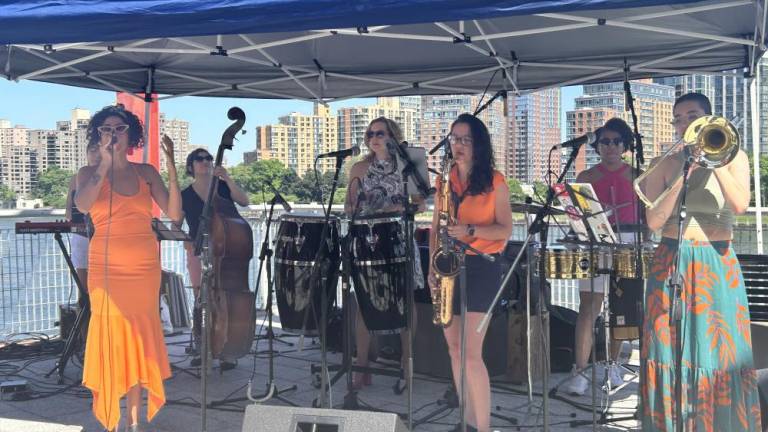 The all women salsa band “Lulada Club,” performing by the East River Waterfront and 60th Street at Andrew Haswell Park on June 1, 2024. Andrea Chavarro, in the orange dress, is the lead singer of the band. Photo: Alessia Girardin.