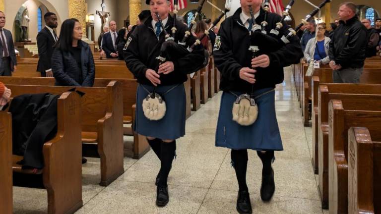 The pipes of St. Francis of Assisi: bagpipers in aisle, organ above.