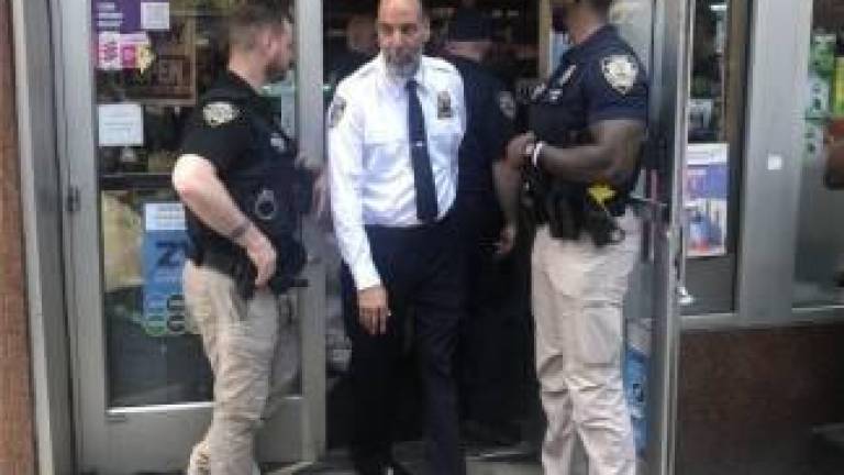 NYC Sheriff Anthony Miranda walking out of an unlicensed marijuana dispensary in May 2024, after a local operation to shut down such stores began. The local program is tied up in court after reportedly closing 1,300 smoke shops, while a state initiative that has closed only 59 shops in Manhattan last year is ongoing.